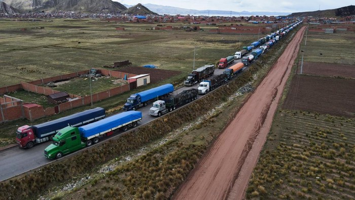 Puluhan Truk Terdampar Gegara Blokade di Perbatasan Peru-Bolivia DESAGUADERO, BOLIVIA - PERU BORDER - JANUARY 18: An aerial view of dozens of Bolivian trucks that were stranded by blockades in the Peruvian sector in Desaguadero, Bolivia, Peru Border on January 18, 2023. The current situation in Peru, where social sectors demand the resignation of the Peruvian president, affected Bolivia in a blockade in the border sector of Desaguadero, a border that unites Peru and Bolivia. (Photo by Luis Gandarillas/Anadolu Agency via Getty Images)