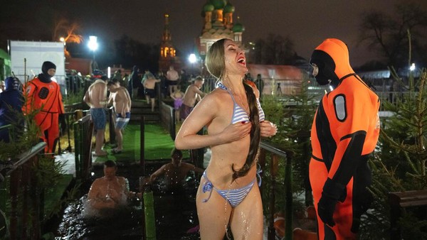 Walaupun suhu pada saat itu berkisar -26C, para jemaat tidak mengurungkan niatnya untuk terjun ke kolam dan sungai. (AP Photo/Alexander Zemlianichenko)  