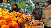 Tampak warga berbelanja di tempat buah-buahan. Mereka membeli jeruk untuk perayaan Imlek.