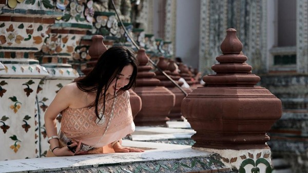 Seorang turis berpakaian tradisional Thailand mengunjungi kuil Wat Arun di Bangkok, Thailand, Senin (16/1/2023). Seorang turis berpakaian tradisional Thailand mengunjungi kuil Wat Arun di Bangkok, Thailand, Senin (16/1/2023).