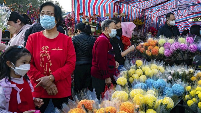 Shoppers purchase orchids at a Lunar New Year flower market in the Causeway Bay district in Hong Kong, Wednesday, Jan. 18, 2023. The Year of the Rabbit officially begins on Jan. 22. (AP Photo/Anthony Kwan)