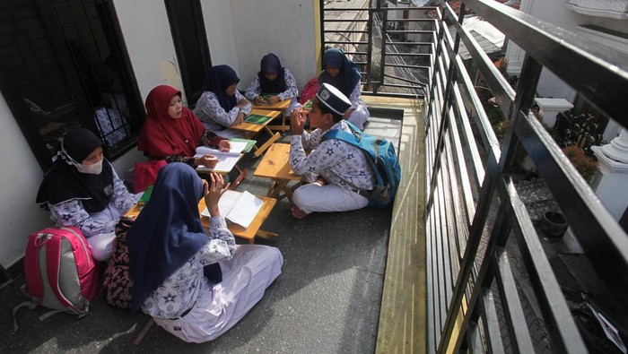 Siswa SD/MI Cokroaminoto mengikuti pelajaran di salah satu rumah warga di kawasan Nyamplungan, Surabaya, Jawa Timur, Kamis (19/1/2023). Pelajar SD/MI Cokroaminoto belajar di sejumlah rumah yang disediakan oleh pihak sekolah karena gedung sekolah YPI Cokroaminoto yang rencananya direnovasi terkendala tidak memiliki izin mendirikan bangunan (IMB) dan disegel Pemkot Surabaya. ANTARA FOTO/Didik Suhartono/nym.