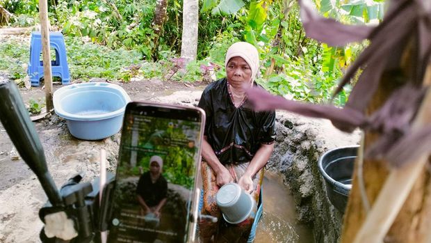 Warga Dusun Pedek Setanggor Timur 2 Desa Setanggor Kecamatan Praya Barat, Lombok Tengah, saat sedang live mandi air keruh di TikTok.