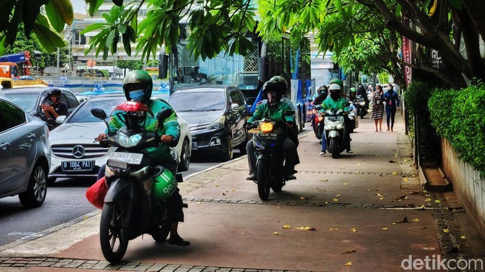 Aksi Nekat Pemotor Serobot Jalur Pejalan Kaki di Thamrin Pengendara motor melintas di jalur pedestrian jalan Thamrin, Jakarta Pusat, Jumat (20/1/2023), untuk menembus kepadatan kendaraan di ruas jalan tersebut. Selain melanggar peraturan lalu-lintas, tindakan tersebut membahayakan pejalan kaki. Foto diambil sekitar pukul 13.30 WIB.