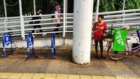Parkir sepeda di halte busway Bendungan Hilir. Di sebelahnya pedagang kaki lima berjualan.