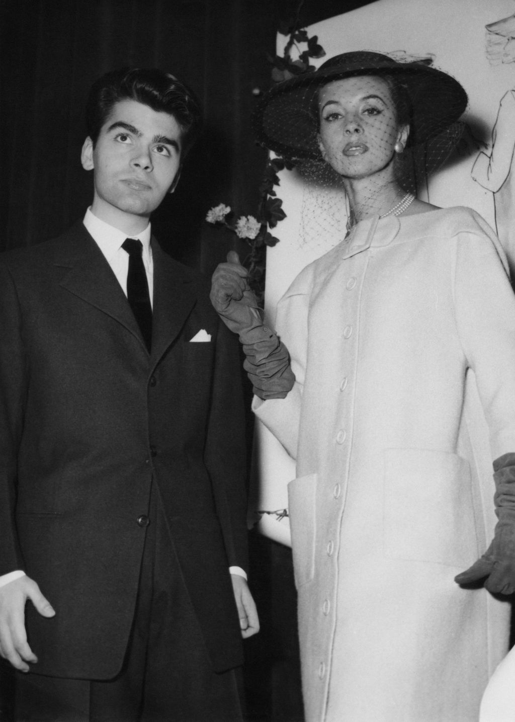 German fashion designer Karl Lagerfeld after winning the coats category in a design competition sponsored by the International Wool Secretariat, Paris, 14th December 1954. With him is a model wearing his design. The competition win led to Lagerfeld being hired as assistant to Pierre Balmain. (Photo by Keystone/Hulton Archive/Getty Images)