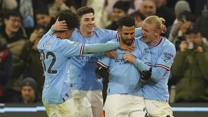 Manchester Citys Riyad Mahrez, second right, celebrates with his teammates after scoring his sides third goal during the English Premier League soccer match between Manchester City and Tottenham Hotspur at the Etihad Stadium in Manchester, England, Thursday, Jan. 19, 2023. (AP Photo/Dave Thompson)