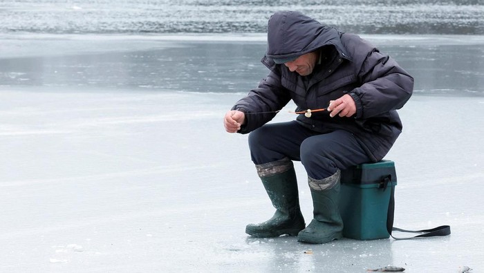 Mancing di Sungai Dnipro yang Membeku Seorang warga sedang memancing di Sungai Dnipro, Kyiv, yang membeku. Dia asyik mancing meski perang Rusia dan Ukraina masih berlanjut.