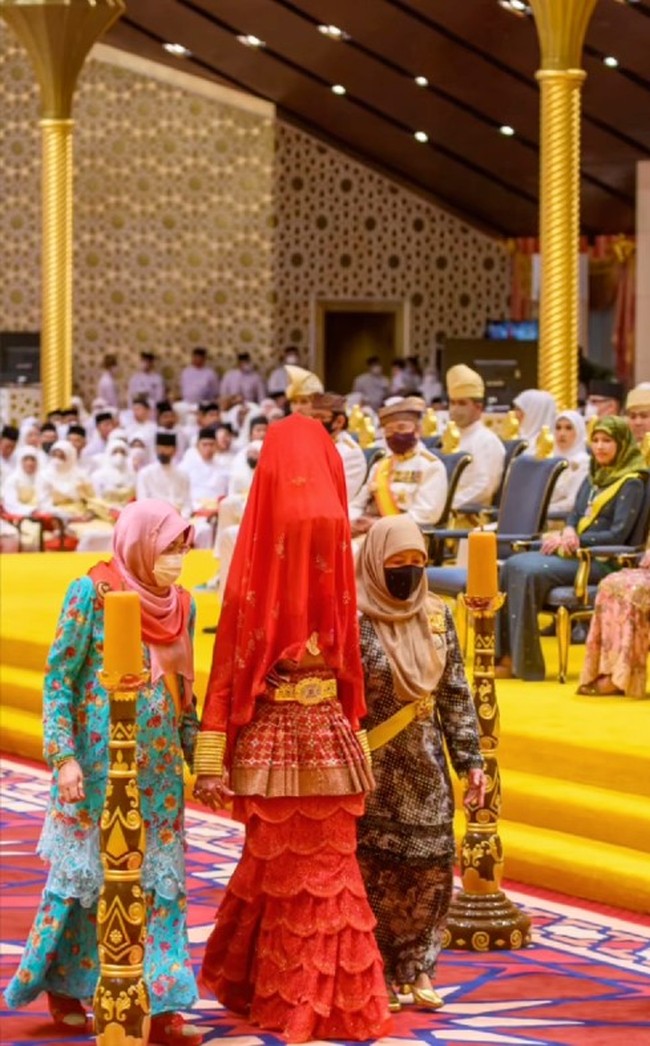 Saat menjalani rangkaian pernikahannya di Istana Nurul Iman, Putri Azemah tampil unik. Wajahnya ditutup kain merah ketika berjalan ke arah pelaminan. Foto: Dok. Instagram Bernard Chandran