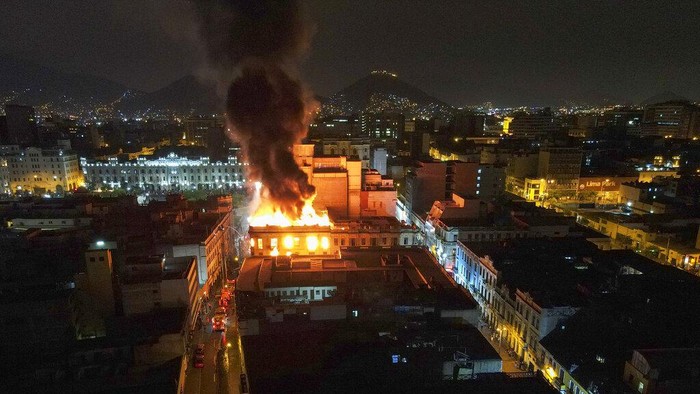Peru Memanas! Aksi Menuntut Presiden Mundur Terus Belanjut A building burns amid anti-government protests in downtown Lima, Peru, Thursday, Jan. 19, 2023. Protesters are seeking immediate elections, the resignation of President Dina Boluarte and the release from prison of ousted President Pedro Castillo. (AP Photo/Martin Mejia)