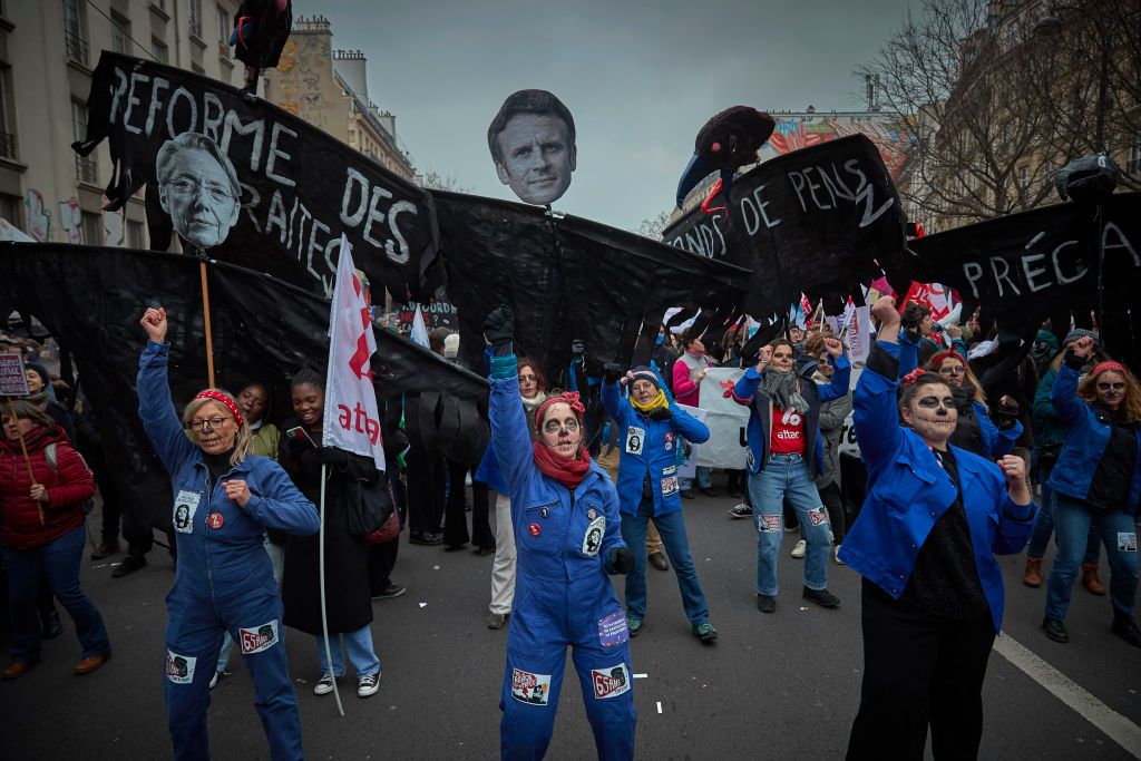 PARIS, FRANCE - JANUARY 19: Protestors march through the streets of Paris as part of nationwide protest and strike against President Macron's Pension reform plans and the rising cost of living on January 19, 2023 in Paris, France. Following the French government's announcement to push the retirement age from 62 to 64, unions have called for mass social action with employees in transport, education, energy and the health service joining the nationwide strike, with major protests across France. France's CGT union has also threatened to cut electricity supplies to lawmakers and businessmen amid the nationwide strike. (Photo by Kiran Ridley/Getty Images)