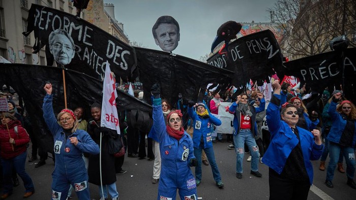 Potret Buruh Demo Besar-besaran di Prancis Tolak Reformasi Pensiun PARIS, FRANCE - JANUARY 19: Protestors march through the streets of Paris as part of nationwide protest and strike against President Macron's Pension reform plans and the rising cost of living on January 19, 2023 in Paris, France. Following the French government's announcement to push the retirement age from 62 to 64, unions have called for mass social action with employees in transport, education, energy and the health service joining the nationwide strike, with major protests across France. France's CGT union has also threatened to cut electricity supplies to lawmakers and businessmen amid the nationwide strike. (Photo by Kiran Ridley/Getty Images)