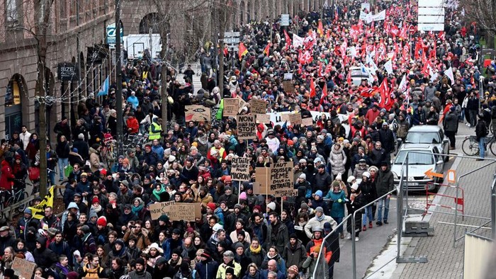 Potret Buruh Demo Besar-besaran di Prancis Tolak Reformasi Pensiun Demonstrators march during a rally in Strasbourg, eastern France, on January 19, 2023, as workers go on strike over the French President's plan to raise the legal retirement age from 62 to 64. - A day of strikes and protests kicked off in France on January 19, set to disrupt transport and schooling across the country in a trial for the government as workers oppose a deeply unpopular pensions overhaul. (Photo by Frederick FLORIN / AFP) (Photo by FREDERICK FLORIN/AFP via Getty Images)