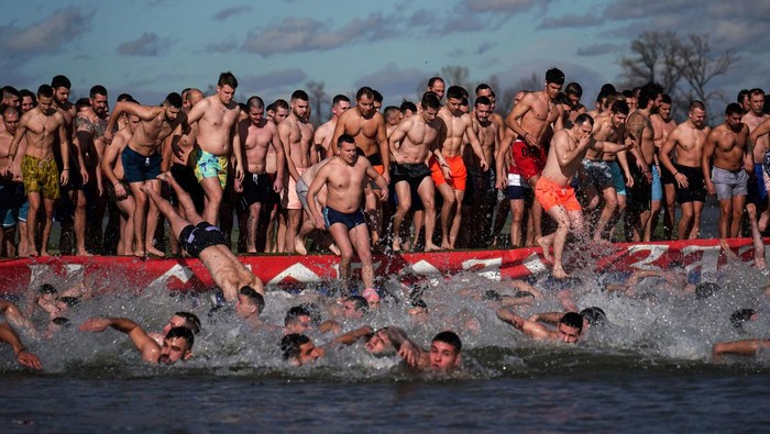 Rayakan Hari Epiphany, Warga Serbia Serempak Berenang di Sungai ES Christian Orthodox believers swim to retrieve a cross from the cold waters of the Danube River in Belgrade on January 19, 2023, as part of Orthodox Epiphany celebrations. (Photo by OLIVER BUNIC / AFP) (Photo by OLIVER BUNIC/AFP via Getty Images)