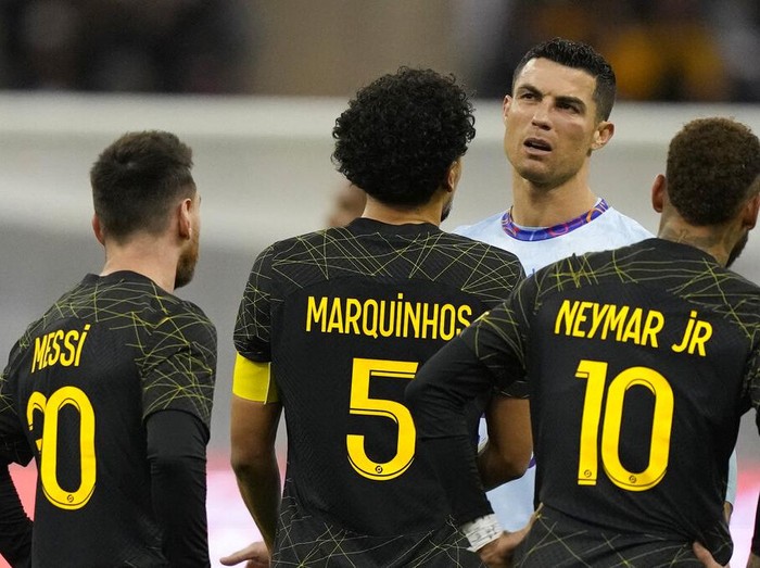 Cristiano Ronaldo grimaces playing for a combined XI of Saudi Arabian teams Al Nassr and Al Hilal is flanked by PSG's Lionel Messi and his teammates Neymar and Marquinhos during a friendly soccer match, at the King Saud University Stadium, in Riyadh, Saudi Arabia, Thursday, Jan. 19, 2023. (AP Photo/Hussein Malla)