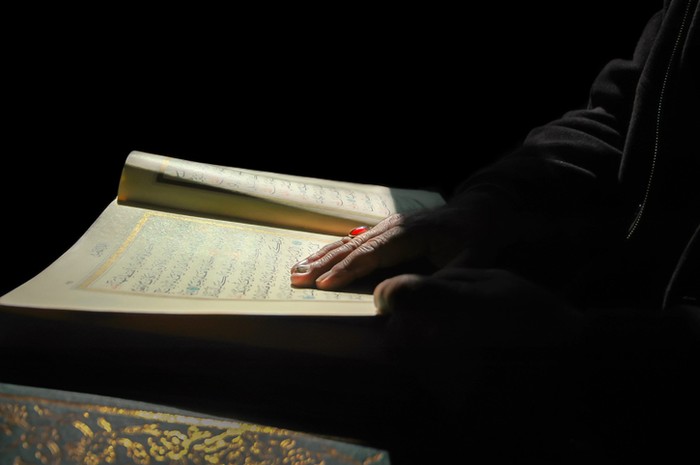 Seorang muslim membaca Al-Quran sebelum tidur.