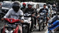 Sepeda motor melintas di antara mobil di Jalan Letjen Suprapto, Jakarta Pusat, Jumat (20/1/2023).