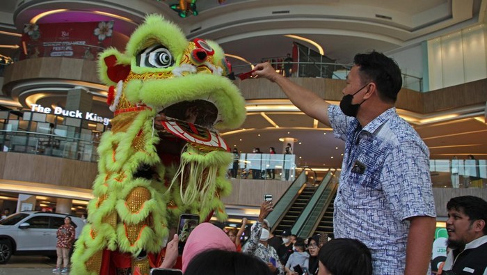 Aksi Barongsai Masuk Mal Jelang Imlek Pemain barongsai dari grup Naga Selatan Jogja berinteraksi dengan pengunjung di Sleman CIty Hall (SCH), Sleman, D.I Yogyakarta, Jumat (20/1/2023). Pertunjukan barongsai yang diselenggarakan oleh pengelola mal tersebut guna menyambut serta memeriahkan Tahun Baru Imlek 2574. ANTARA FOTO/Andreas Fitri Atmoko/aww.