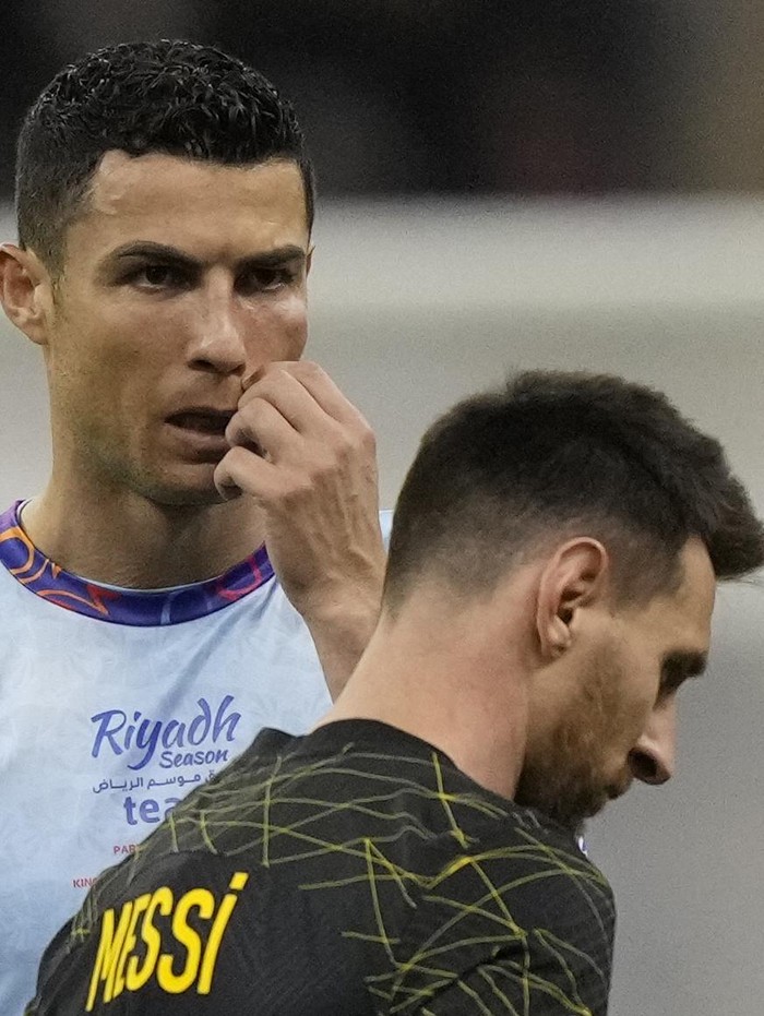 Cristiano Ronaldo gestures playing for a combined XI of Saudi Arabian teams Al Nassr and Al Hilal is flanked by PSGs Lionel Messi during a friendly soccer match, at the King Saud University Stadium, in Riyadh, Saudi Arabia, Thursday, Jan. 19, 2023. (AP Photo/Hussein Malla)