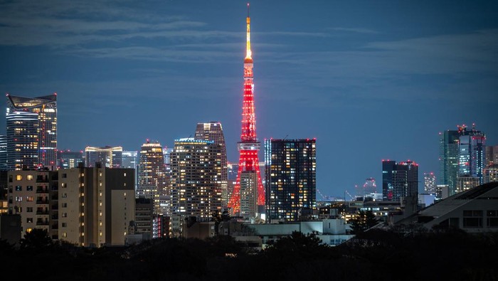 Menara Tokyo Menyala Merah Rayakan Imlek People wait to cross a street as Tokyo Tower is lit in red to celebrate the Chinese Lunar New Year in Tokyo on January 21, 2023. (Photo by Yuichi YAMAZAKI / AFP) (Photo by YUICHI YAMAZAKI/AFP via Getty Images)