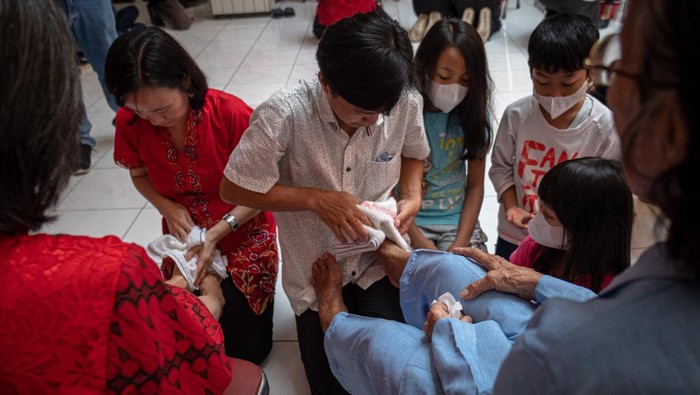 Momen Haru Basuh Kaki Orang Tua Sebelum Rayakan Imlek Sejumlah warga Tionghoa saling memeluk seusai pembasuhan kaki orang tua saat mengikuti tradisi Bakti Basuh Kaki Orang Tua di Gedung Rasa Dharma (Boen Hian Tong) Kawasan Pecinan Semarang, Jawa Tengah, Sabtu (21/1/2023). Tradisi dalam rangka menyambut Tahun Baru Imlek 2574 dengan membasuh kaki orang tua atau kerabat yang lebih tua dan dilanjutkan saling memaafkan tersebut sebagai simbol pembaktian anak kepada orang tua. ANTARA FOTO/Aji Styawan./YU