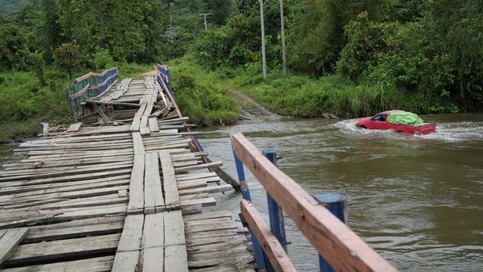 Seorang guru menggendong siswa SD Negeri 1 Alaaha saat menyeberangi jembatan rusak di Desa Alaaha, Kecamatan Ueesai, Kolaka Timur, Sulawesi Tenggara, Sabtu (21/1/2023). Jembatan yang menjadi akses satu-satunya dan penghubung tiga desa tersebut rusak akibat lapuk serta dorongan arus deras sungai Wandolaki sehingga menyebabkan sekitar 1.850 jiwa diwilayah tersebut tidak bisa beraktivitas normal. ANTARA FOTO/Jojon/YU
