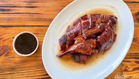 Pencinta bebek bisa puaskan selera dengan bebek panggang. Disajikan dengan cocolan saus hoisin, daging bebek di sini lembut gurih!