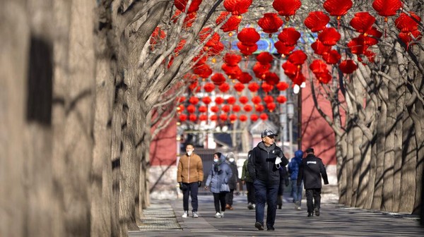 Orang-orang berjalan sambil menikmati indahnya dekorasi Imlek di sebuah taman di Beijing. Imlek tahun ini menandai tahun Kelinci Air.