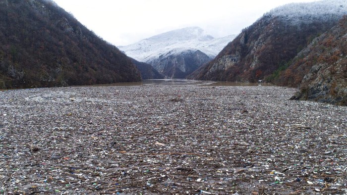 Penampakan ‘Pulau Sampah’ di Sungai Drina Bosnia Aerial view of waste floating in the Drina river near Visegrad, Bosnia, Friday, Jan. 20, 2023. Tons of waste dumped in poorly regulated riverside landfills or directly into the rivers across three Western Balkan countries end up accumulating during high water season in winter and spring, behind a trash barrier in the Drina River in eastern Bosnia. (AP Photo/Armin Durgut)
