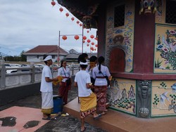 Rombongan keluarga datang ke vihara mengenakan pakaian adat Bali. Foto: Nuranda Indrajaya/detikBali