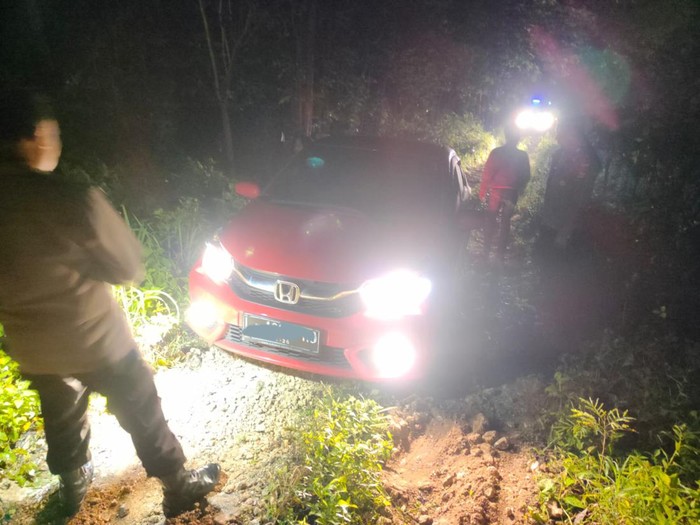Polisi dan warga membantu mobil yang tersesat di Pedukuhan Petung, Kalurahan Giriwungu, Kapanewon Panggang, Kabupaten Gunungkidul, Minggu (22/1/2023) dini hari.
