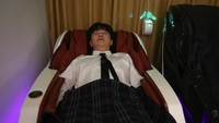 Seorang pekerja kantoran tengah menikmati tidur di kafe. 