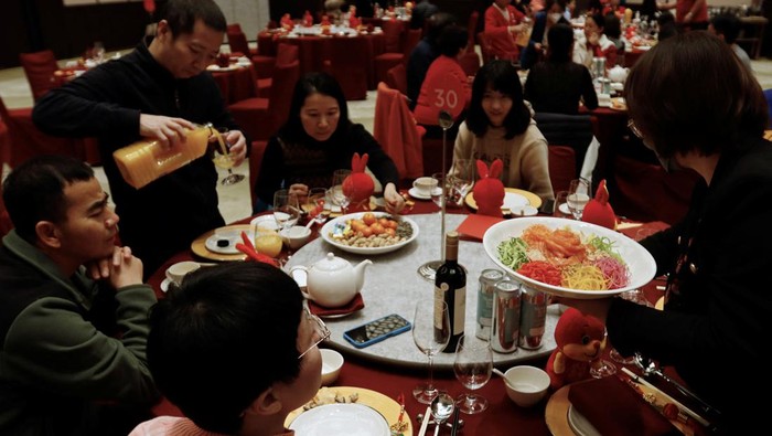A staff member serves food to a table during a Lunar New Years Eve dinner service at Shangri-La Shougang Park hotel in Beijing, China, January 21, 2023. REUTERS/Florence Lo