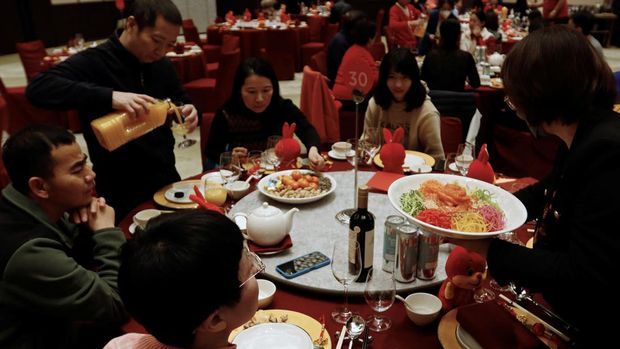 A staff member serves food to a table during a Lunar New Year's Eve dinner service at Shangri-La Shougang Park hotel in Beijing, China, January 21, 2023. REUTERS/Florence Lo