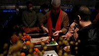 Seorang koki menyajikan babi guling panggang kepada pelanggan saat acara makan malam Malam Tahun Baru Imlek di hotel Shangri-La Shougang Park di Beijing, China, Sabtu (21/1/2023).  