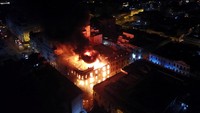 Asap dan api mengepul dari sebuah gedung selama pawai Ambil alih Lima untuk berdemonstrasi menentang Presiden Peru Dina Boluarte, menyusul penggulingan dan penangkapan mantan Presiden Pedro Castillo, di Lima, Peru, Kamis (19/1/2023).Reuters/Pilar Olivares