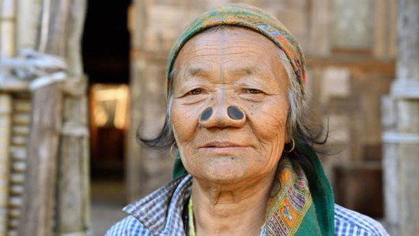 Perempuan Suku Apatani terlihat tangguh dan unik dengan mengenakan sumbat hidung dari kayu yang besar di sisi lubang hidung mereka dan tato vertikal yang melintasi wajah dan dagu mereka. Konon, perempuan Apatani dianggap yang paling cantik di wilayah itu. Tujuan awal dari tato dan sumbat hidung yang unik itu adalah membuat perempuan Apatani terlihat kurang atraktif sehingga para laki-laki dari suku lain tidak mau menikahi mereka. Getty Images/rchphoto Perempuan Suku Apatani terlihat tangguh dan unik dengan mengenakan sumbat hidung dari kayu yang besar di sisi lubang hidung mereka dan tato vertikal yang melintasi wajah dan dagu mereka. Konon, perempuan Apatani dianggap yang paling cantik di wilayah itu. Tujuan awal dari tato dan sumbat hidung yang unik itu adalah membuat perempuan Apatani terlihat kurang atraktif sehingga para laki-laki dari suku lain tidak mau menikahi mereka. Getty Images/rchphoto