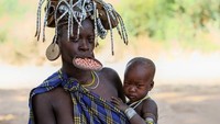 Piring dan bibir bukanlah sesuatu yang lazim dipasangkan. Tapi tradisi turun-temurun Suku Mursi, yang tinggal di sekitar Danau Turkana dan Lembah Omo di Selatan Ethiopia, bisa memadukan keduanya. Bagi suku Mursi, pelat bibir yang besar dengan berbagai warna adalah simbol kecantikan yang luar biasa. Aksesori yang mengesankan ini lebih sering dikenakan oleh wanita yang baru menikah dan wanita yang belum menikah dibandingkan oleh wanita bersuami yang lebih tua dan sudah punya anak. Pelat bibir ini biasanya dikenakan pada acara tertentu dan ritual penting, seperti pernikahan. Getty Images/Henk Bogaard