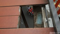 Jembatan dengan material kayu tersebut nampak bolong.