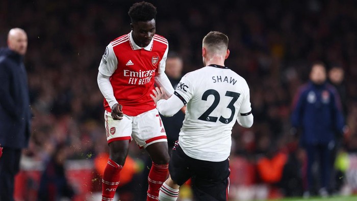 Soccer Football - Premier League - Arsenal v Manchester United - Emirates Stadium, London, Britain - January 22, 2023 Arsenals Bukayo Saka in action with Manchester Uniteds Luke Shaw REUTERS/David Klein EDITORIAL USE ONLY. No use with unauthorized audio, video, data, fixture lists, club/league logos or live services. Online in-match use limited to 75 images, no video emulation. No use in betting, games or single club /league/player publications.  Please contact your account representative for further details.
