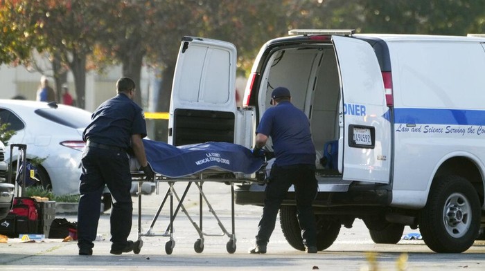 The body of Huu Can Tran is retrieved from a van by the Los Angeles County coroner in Torrance, Calif., Sunday, Jan. 22, 2023. Authorities say, Tran, the suspect in a California dance club shooting that left multiple people dead, shot and killed himself. (AP Photo/Damian Dovarganes)