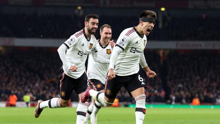LONDON, ENGLAND - JANUARY 22: Lisandro Martinez celebrates with Bruno Fernandes and Christian Eriksen of Manchester United after scoring the teams second goal during the Premier League match between Arsenal FC and Manchester United at Emirates Stadium on January 22, 2023 in London, England. (Photo by Catherine Ivill/Getty Images)