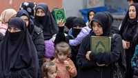 Para demonstan memprotes sembari memegang Al-Qur’an dan spanduk.