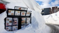 Restoran cepat saji sebagian terkubur di gundukan salju di Danau Mammoth, California, Amerika Serikat, Minggu (22/1/2023).