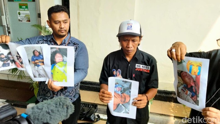 Devi Athok (bertopi) tunjukan foto jenazah 2 anaknya di PN Surabaya