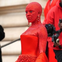 Riasan tersebut menyempurnakan penampilan Doja yang dibungkus mini-dress bustier dengan rok penuh mote kayu mengilap. Tidak ketinggalan aksesori berupa anting, serta sepatu boots trompe lœil berhiasakan bentuk jari kaki tiga dimensi, dan semacam selendang yang menjuntai panjang. (Foto: Getty Images)