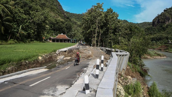 JALAN PENGHUBUNG DESA WISATA AMBLAS Pengendara sepeda motor melintas di jalan penghubung desa yang amblas di Sriharjo, Bantul, DI Yogyakarta, Senin (23/1/2023). Jalan penghubung desa wisata Sriharjo dengan Selopamioro yang sudah beberapa kali diperbaiki itu amblas, dan rencananya Pemkab Bantul akan bekerja sama dengan pakar geologi untuk melakukan berbaikan jalan tersebut. ANTARA FOTO/Hendra Nurdiyansyah/tom.
