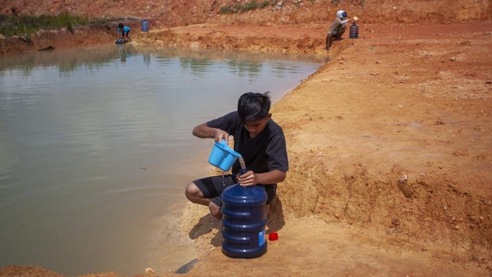 Warga mengambil air kolam tampungan hujan untuk kebutuhan sehari-hari di dekat kawasan Bandara Internasional Hang Nadim, Batam, Kepulauan Riau, Minggu (22/1/2023). Warga di kawasan tersebut kesulitan mendapatkan air bersih disebabkan kurangnya pasokan dari Perusahaan Daerah Air Minum (PDAM) Batam sehingga warga terpaksa menggunakan air tampungan hujan ataupun membeli air bersih untuk memenuhi kebutuhan sehari-hari. ANTARA FOTO/Teguh Prihatna/rwa.