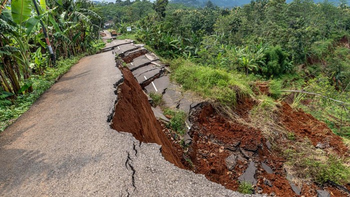 Foto udara seorang warga mengamati kondisi jalur penghubung alternatif Ungaran, Kabupaten Semarang - Mranggen, Kabupaten Demak yang terputus di Desa Kalongan, Kecamatan Ungaran Timur, Kabupaten Semarang, Jawa Tengah, Selasa (24/1/2022). Putusnya jalur penghubung antarkabupaten tersebut terjadi secara bertahap sejak Februari 2022, Oktober 2022, dan Januari 2023 akibat tanah gerak disertai longsor jalan sepanjang 200 meter dengan kedalaman 50 meter serta cakupan tanah gerak sekitar 16 hektare, sementara itu Pemkab Semarang mengalokasikan anggaran Rp3 miliar untuk perbaikan jalan perkampungan sebagai jalur alternatif pengalihan lalu lintas. ANTARA FOTO/Aji Styawan/aww.