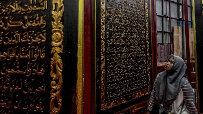 PALEMBANG, INDONESIA - JANUARY 23: People visit the Bayt Al Quran Al Akbar Museum in Palembang, Indonesia on January 23, 2023. Parts of Holy Quran were beautifully carved on the 1,77 x 1,4 meters wide and 2,5 cm thick Tembesu wood at the 5-storey building. (Photo by Muhammad A.F/Anadolu Agency via Getty Images)